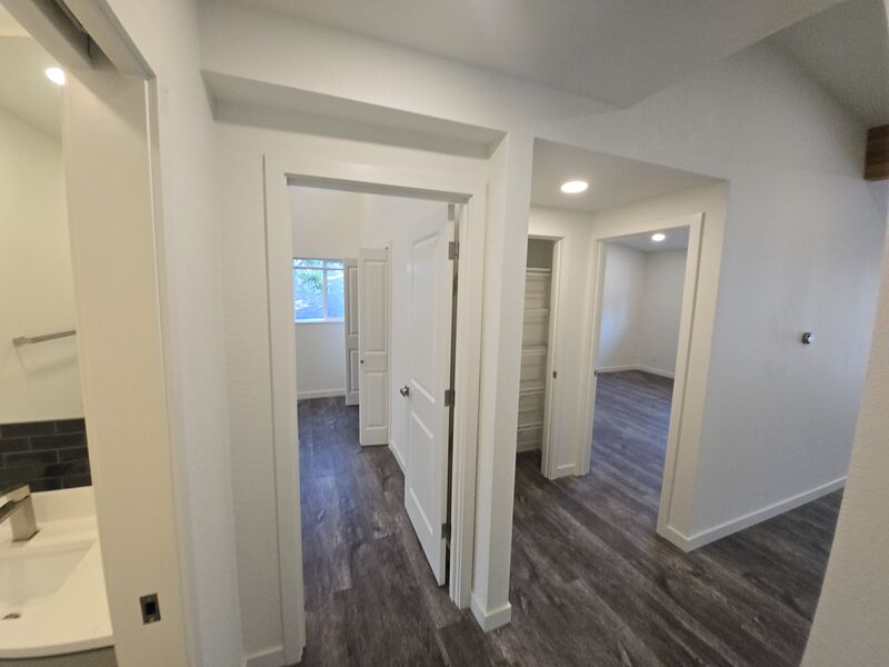 Hallway connecting bedrooms with new flooring and natural light
