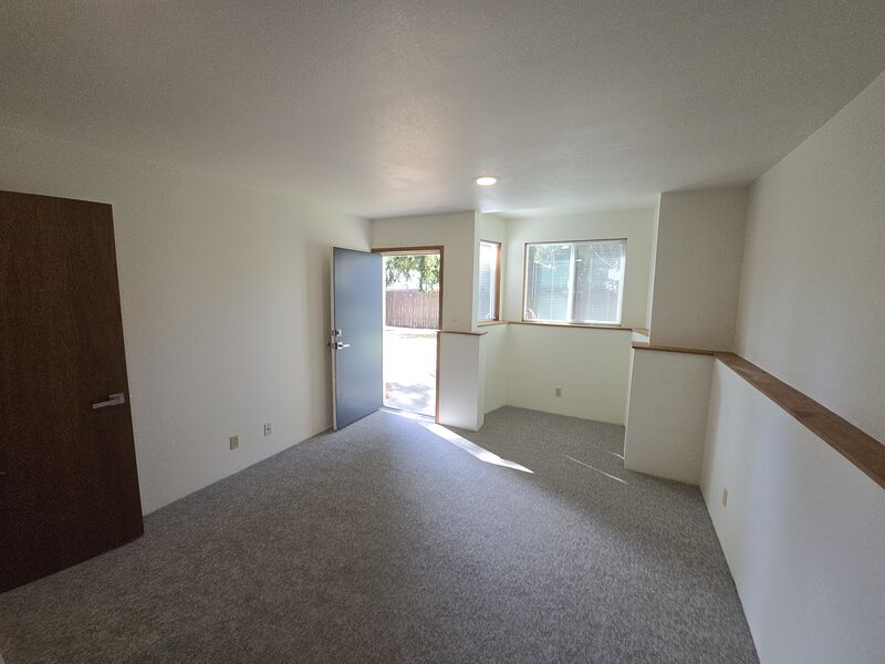 Lower-level bedroom with corner daylight windows and a walkout door to the back yard